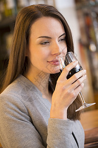 美丽的年轻美女在餐厅里喝红酒的肖像图片