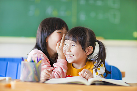 可爱的小女孩向妹妹低声说话图片