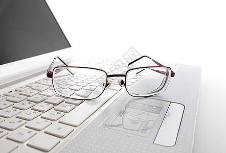 笔记本电脑键盘上的眼眼镜屏幕喘息桌面眼镜桌子白色静物办公室背景图片