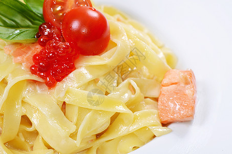 配三文鱼和奶油酱的Fettuccini海鲜食物午餐叶子面条白色宏观盘子美食图片