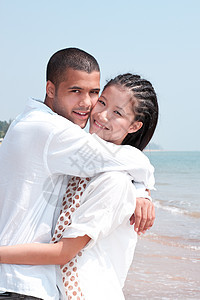 非洲男人和亚洲女人在海滩上的爱人蓝色乐趣假期喜悦女士夫妻小猪男性女孩感情图片