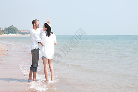 非洲男人和亚洲女人在海滩上的爱人海洋假期小猪女性女孩蓝色喜悦女士夫妻男性图片