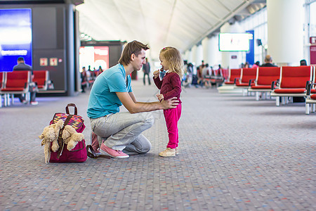 在机场的小女孩和小爸爸 等待飞机飞到机场运输航班乘客行李父亲游客木板飞机场女孩家庭图片