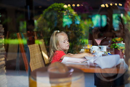 睡觉的小女孩在窗外一个美丽的咖啡厅里 可爱的小女孩微笑婴儿食物喜悦早餐女儿孩子女性快乐窗口背景