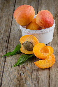 木桌上的杏子木板叶子种子甜点水果宏观植物橙子桌子维生素图片