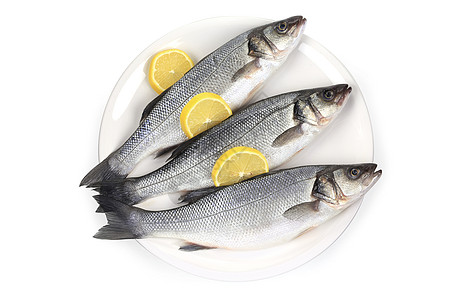 盘子上有三个生海盆低音烹饪柠檬鼠科海鲜钓鱼食物圆形宏观黑色图片