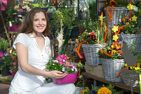 花店的女子在花间安排花朵客户插花市场花园零售花园女性中心店铺盆栽图片
