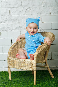 小男孩坐在阳台椅子上微笑情绪男生闲暇童年幸福柳条婴儿眼睛幼儿园图片