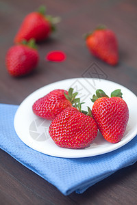 木质表面板块上的红色多汁草莓营养盘子浆果烹饪食物甜点桌子木头野餐美味图片