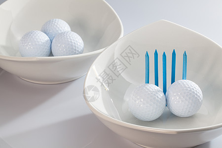 白陶瓷碗和高尔夫球材料桌子圆圈菜肴球座木头黑色橙子镜子运动图片