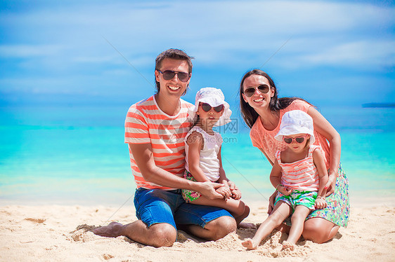 四口四口家庭在热带岛屿上快乐海滩度假图片
