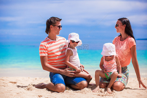 四口的年轻美丽家庭 享受沙滩上放松的快乐海岸线父亲父母海岸幸福女儿母亲孩子婴儿热带图片