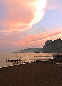 日落时山 海 沙滩背景图片