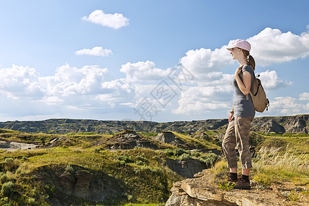 在加拿大艾伯塔省恶地的隐居者沉积地形场景石头天空悬崖青少年远足者女士边缘图片