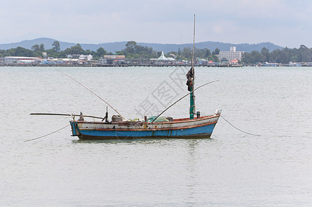 小型渔船木头海岸发动机钓鱼反射天空假期晴天渔业支撑图片