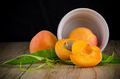 木桌上的杏子黄色植物叶子桌子维生素橙子木板宏观种子甜点图片