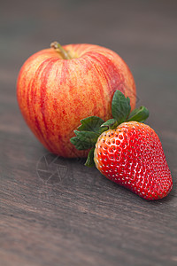 木质表面的多汁苹果和草莓图片