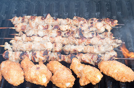 鱼叉和烤鸡翅在烤架上午餐鸡翅炙烤食物肋骨花环牛肉营养猪肉火焰图片