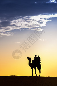 沙漠的当地人带着骆驼走过Thar沙漠太阳光沙丘男人射线戏剧性日出冒险场景鼻子天空图片