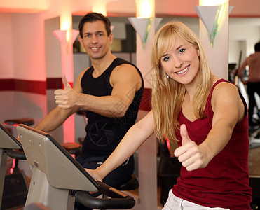 迷人的女人和男人在健身房骑自行车成年人运动机运动装女士有氧运动训练运动女性运动服机器图片