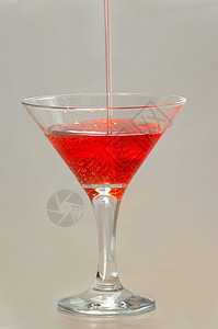 倒在马提尼玻璃杯中的滴水雨滴运动气泡液体飞溅蓝色紫色酒精饮料图片