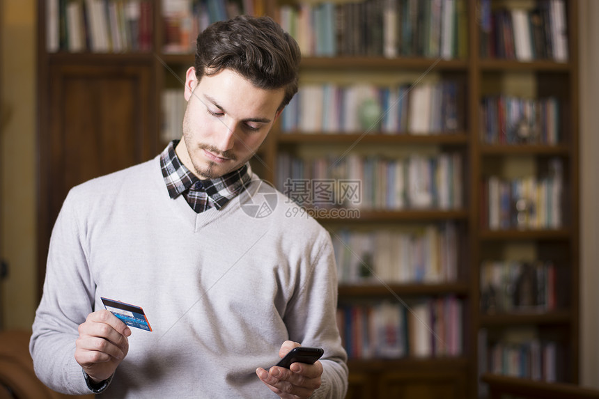 英俊的年轻人在网上用手机购物图片