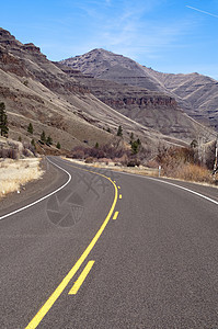 孤独的两条单道分割公路通过干旱山区景观切断公路图片