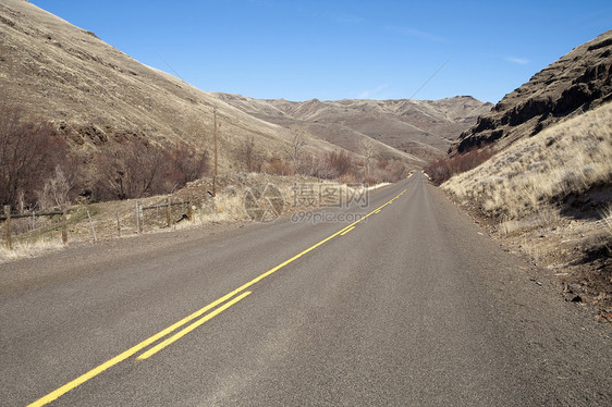 孤独的拖车道分割公路横跨干山地貌图片