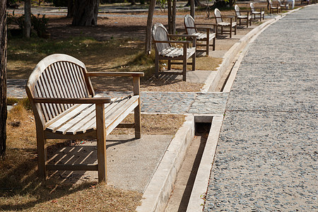 走廊附近的木制长凳植物叶子家具木头座位衬套石头椅子休息街道图片