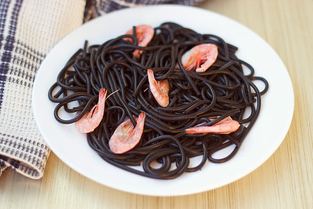 带虾的黑玉米饼食物面条香菜黑色午餐白色美食胡椒乌贼餐巾图片