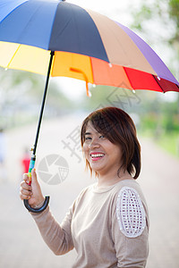 身持伞状的亚洲妇女肖像喜悦成人日落行动创造力天气季节衬衫女士阴影图片