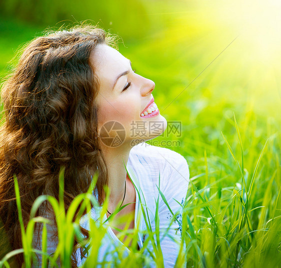 美丽的春春女青年外出门享受大自然女性天空草地自由公园太阳说谎季节晴天牙齿图片