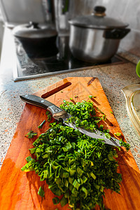 绿洋葱和木板上的厨房植物盘子韭菜烹饪桌子美食餐厅蔬菜叶子图片