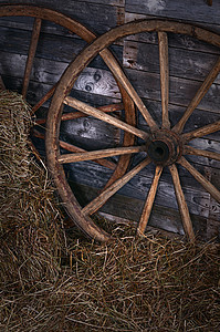 旧木轮在干草上木头大车运输金属圆圈历史木材手工旅行车皮图片