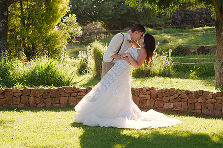 在花园婚礼上亲吻新娘和新郎男人套装教会女士庆典女性新婚裙子仪式幸福图片