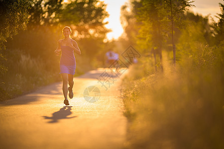 年轻女子在阳光明媚的夏日夜晚户外奔跑跑步女孩赛跑者寒冷娱乐运动装慢跑者闲暇活力火车图片