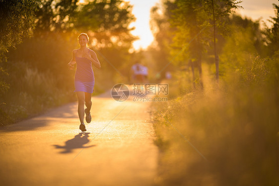 年轻女子在阳光明媚的夏日夜晚户外奔跑跑步女孩赛跑者寒冷娱乐运动装慢跑者闲暇活力火车图片