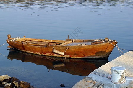旧划船阳光支撑木头血管钓鱼漂浮太阳池塘海洋图片