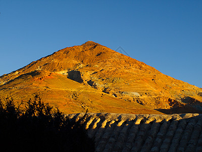 红色夜晚阳光下银山的银山矿石墙壁建筑景观爬坡历史金属矿业天空教会图片