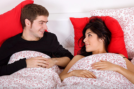 在床上的夫妇微笑男生卧室苏醒男朋友唤醒妻子女孩幸福时间图片