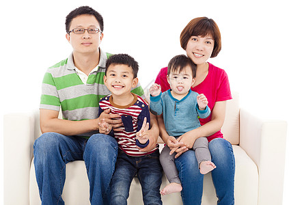 坐在白皮沙发上快乐的亚人家庭成人团体乐趣儿子男人喜悦女士舌头微笑母亲图片