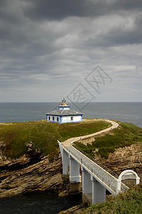 灯塔孤独旅游岩石观光者悬崖植被假期情景石头海岸图片