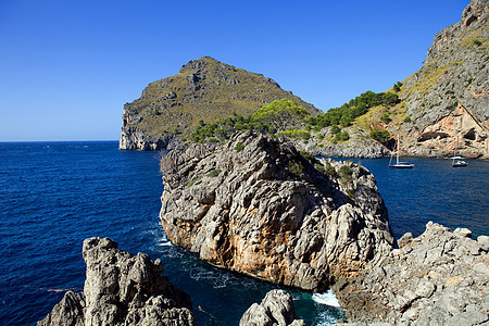 中转石旅游石头帆船海岸线闲暇岩石海洋航行植物旅行图片