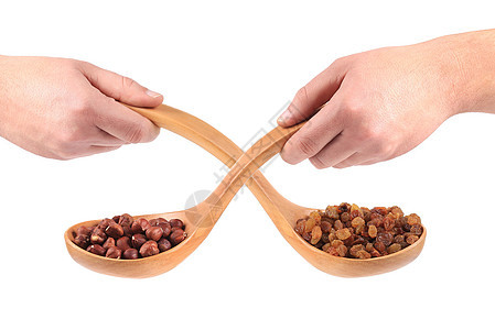 两个勺子和坚果和葡萄干的拼凑图片