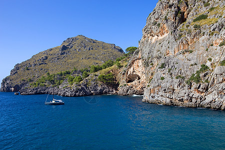 中转石海岸线植物岩石蓝色海洋帆船热带假期旅行悬崖图片