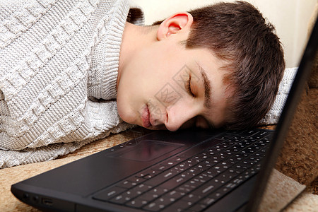 青少年在笔记本电脑上睡觉瞌睡小憩沙发说谎青年男性小伙子房间睡眠毛衣图片