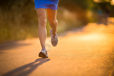 年轻女子在阳光明媚的夏日夜晚户外奔跑青年娱乐越野寒冷草地运动装慢跑者女孩运动员赛跑者图片