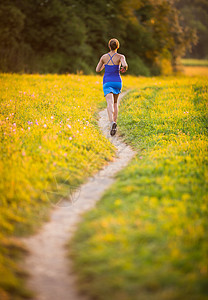 年轻女子在阳光明媚的夏日夜晚户外奔跑慢跑者慢跑城市运动装越野闲暇活力寒冷公园赛跑者图片