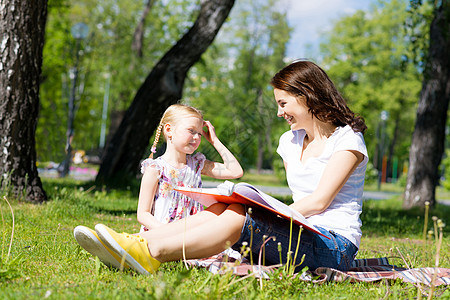 女孩和年轻女子一起阅读一本书托儿所老师女儿女性绘画喜悦场地家庭乐趣女士图片