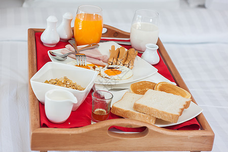 早餐放在床上餐盘上图片